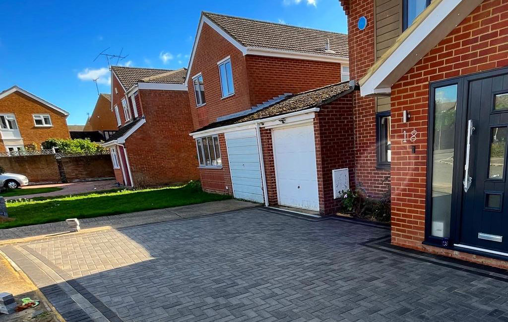 Charcoal block paved driveway running to two garages