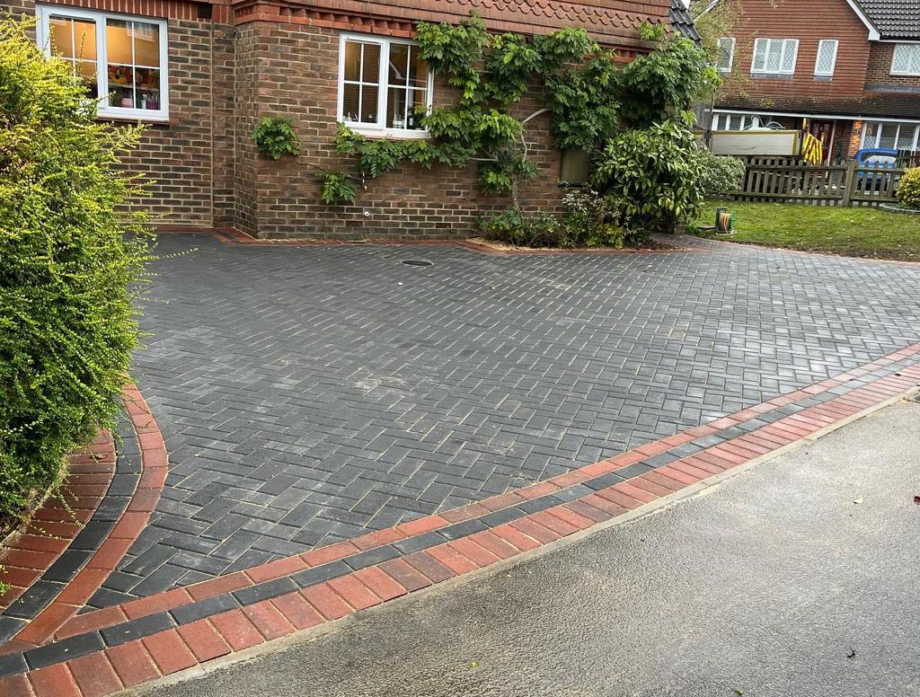 Charcoal block paved driveway with red brick edge courses, laid by Elite Block Paving in Berkshire