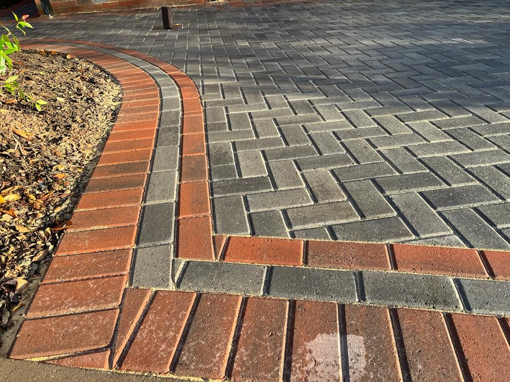 Close detail of curved red and charcoal block paving edge courses