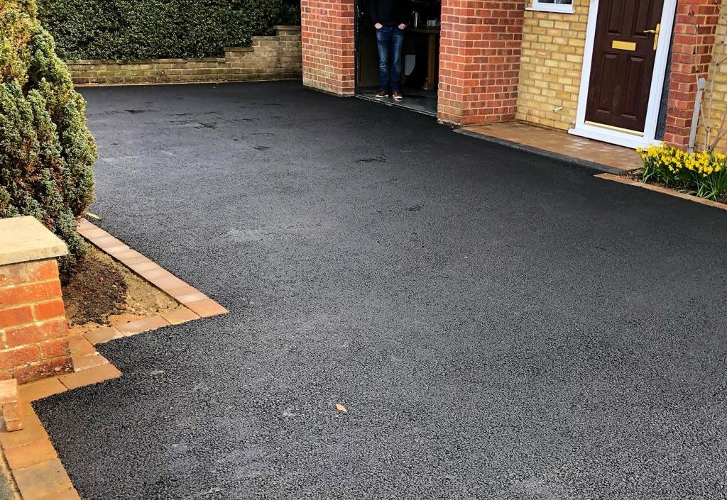 Smooth black tarmac driveway with brick edging at a Berkshire home